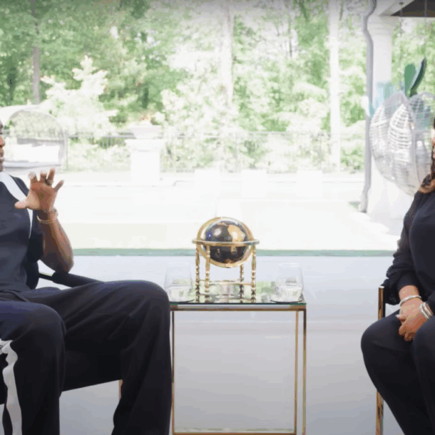 Alicia Lyttle and Nehemiah Davis in a live interview discussing AI automation for entrepreneurs, seated in a modern studio with floor-to-ceiling windows.