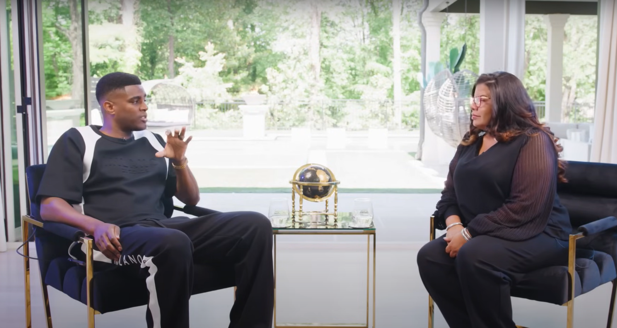 Alicia Lyttle and Nehemiah Davis in a live interview discussing AI automation for entrepreneurs, seated in a modern studio with floor-to-ceiling windows.