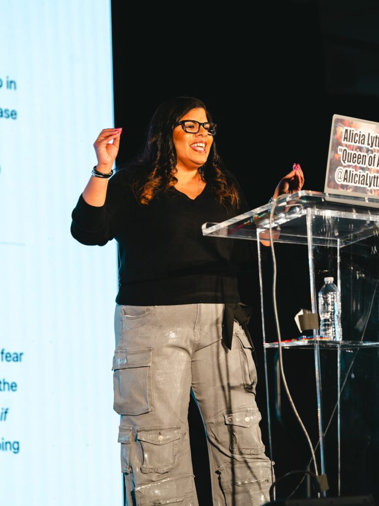 Alicia Lyttle presenting at AI Fueled Profits Live, guiding attendees through hands-on business builds and AI automation strategies.