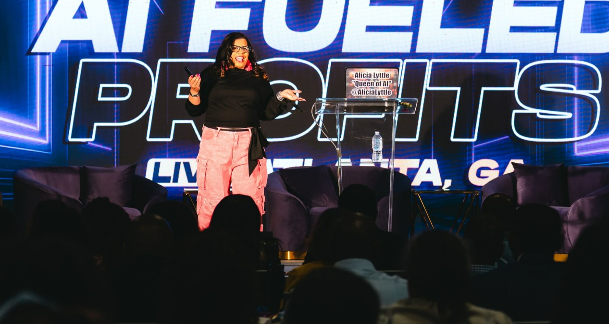 Alicia Lyttle speaking on stage at AI Fueled Profits Live in Atlanta, delivering strategies to entrepreneurs and AI consultants.